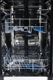 Photo of Open clean empty dishwasher machine, closeup. Home appliance