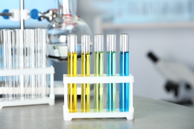 Test tubes with colorful liquids on grey stone table in laboratory