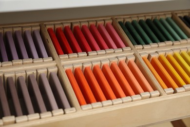 Photo of Wooden box with color tablets on shelf, closeup. Montessori toy