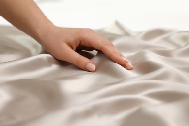 Photo of Woman touching smooth silky fabric, closeup view