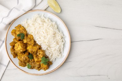 Photo of Delicious chicken curry with rice on white wooden table, top view. Space for text