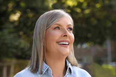 Photo of Portrait of beautiful happy senior woman outdoors