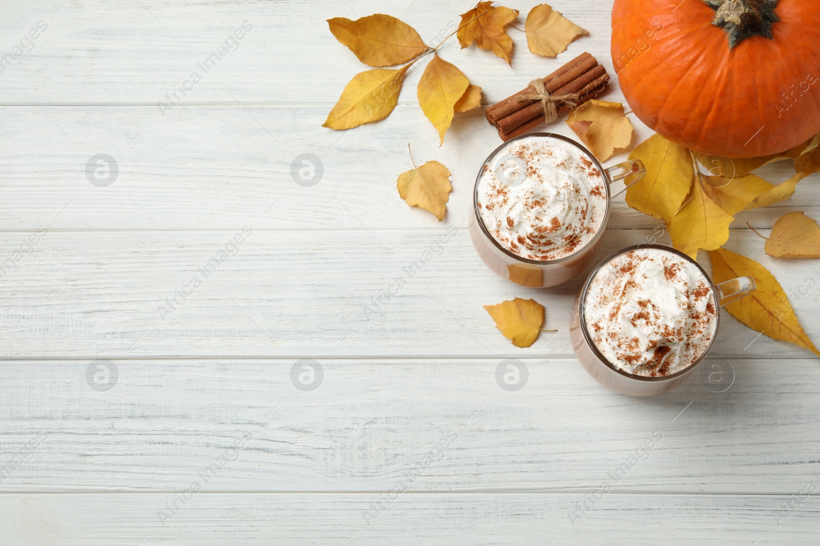 Photo of Delicious pumpkin latte on white wooden table, flat lay. Space for text
