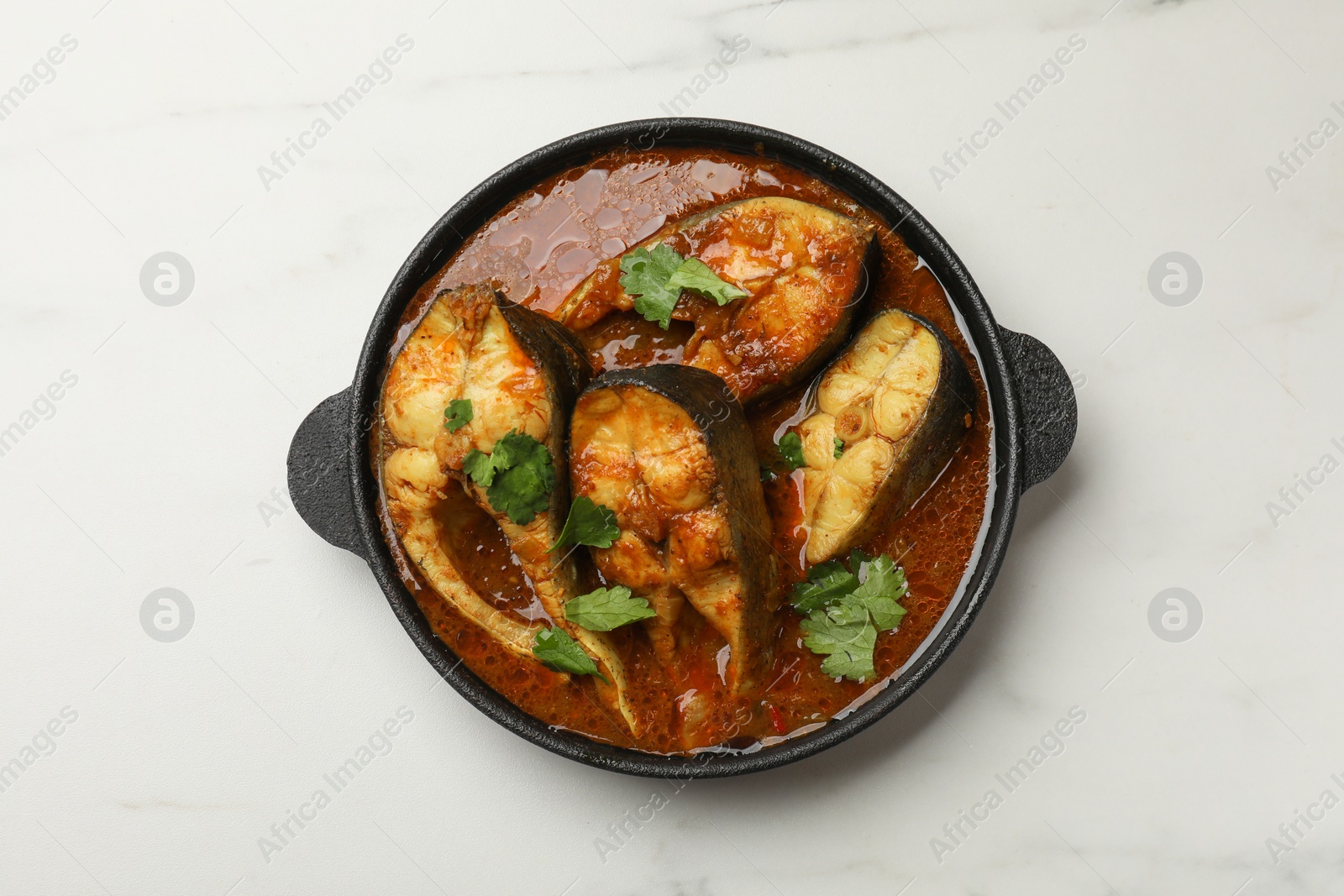 Photo of Tasty fish curry on white marble table, top view. Indian cuisine