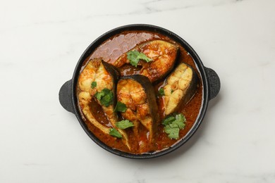 Photo of Tasty fish curry on white marble table, top view. Indian cuisine