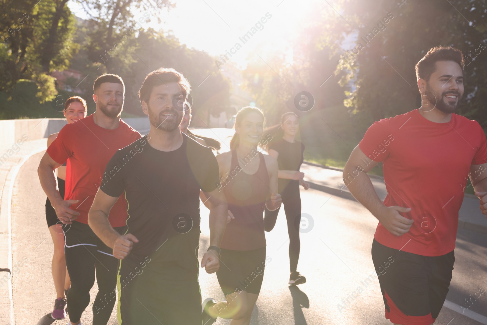 Photo of Group of people running outdoors on sunny day