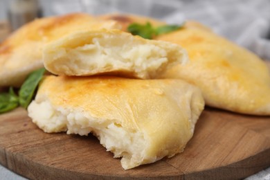 Photo of Delicious samosas and basil on wooden board, closeup