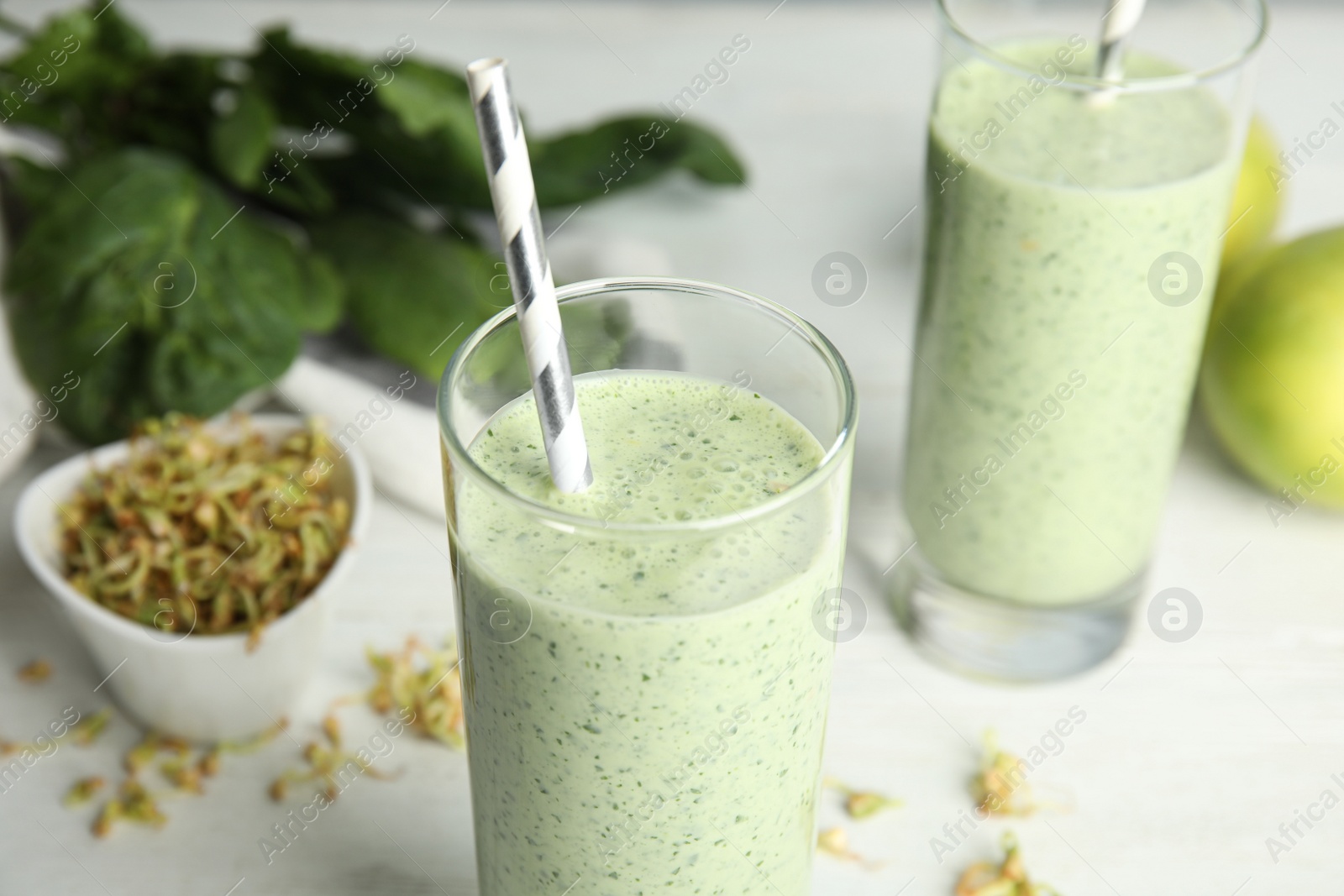 Photo of Green buckwheat smoothie on white table, closeup