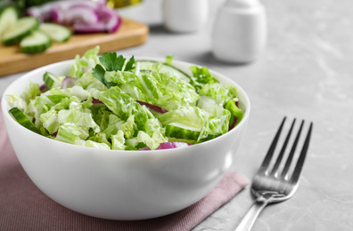 Photo of Tasty salad with cabbage and cucumbers on light grey marble table, closeup