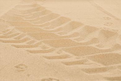 Car tire tracks on beach sand, closeup