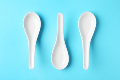 Miso soup spoons on blue background, flat lay