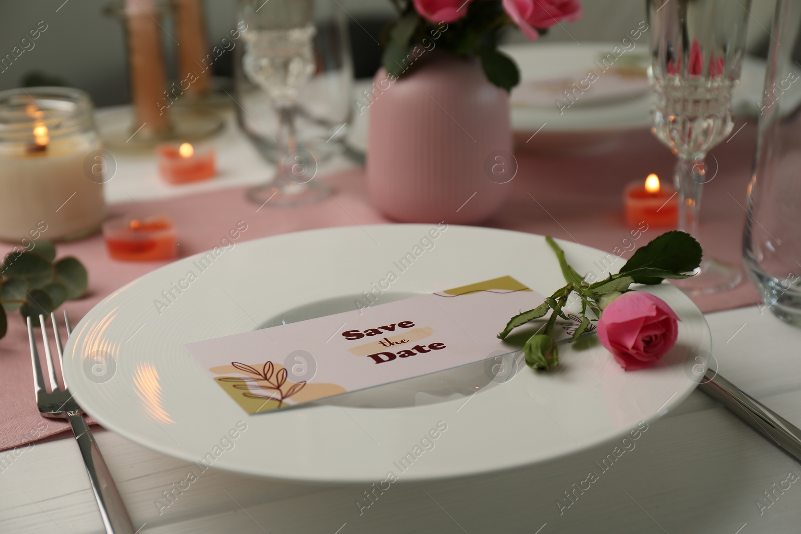 Photo of Romantic table setting with flowers and candles, closeup