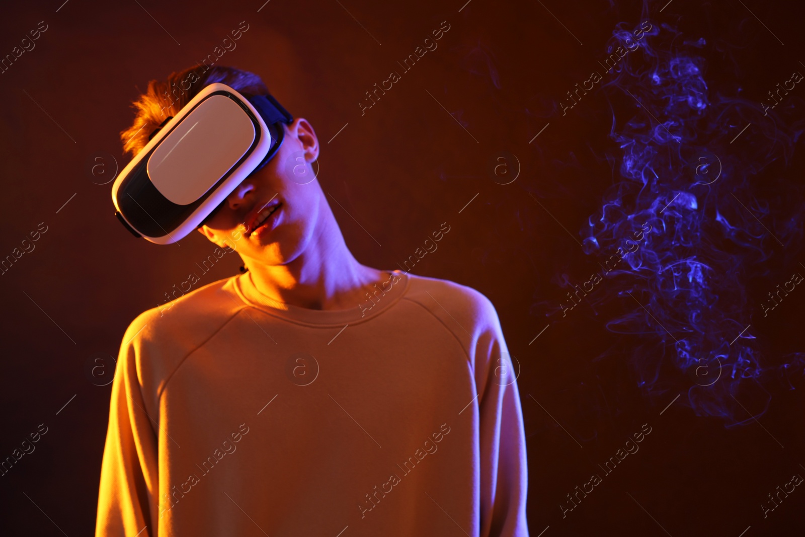 Photo of Young man with virtual reality headset on brown background