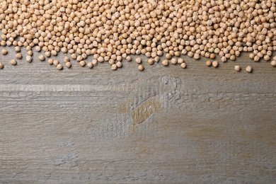 Photo of Chickpeas on wooden table, flat lay. Space for text