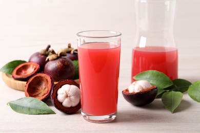 Photo of Delicious mangosteen juice and fresh fruits on white table