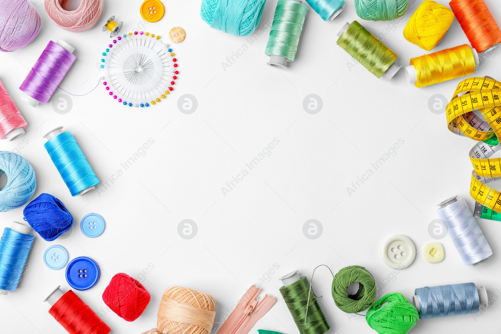 Photo of Composition with color sewing threads on white background, top view