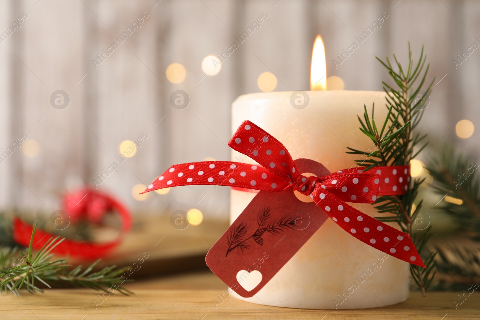 Photo of Burning candle with pinecone scent on wooden table, closeup. Space for text