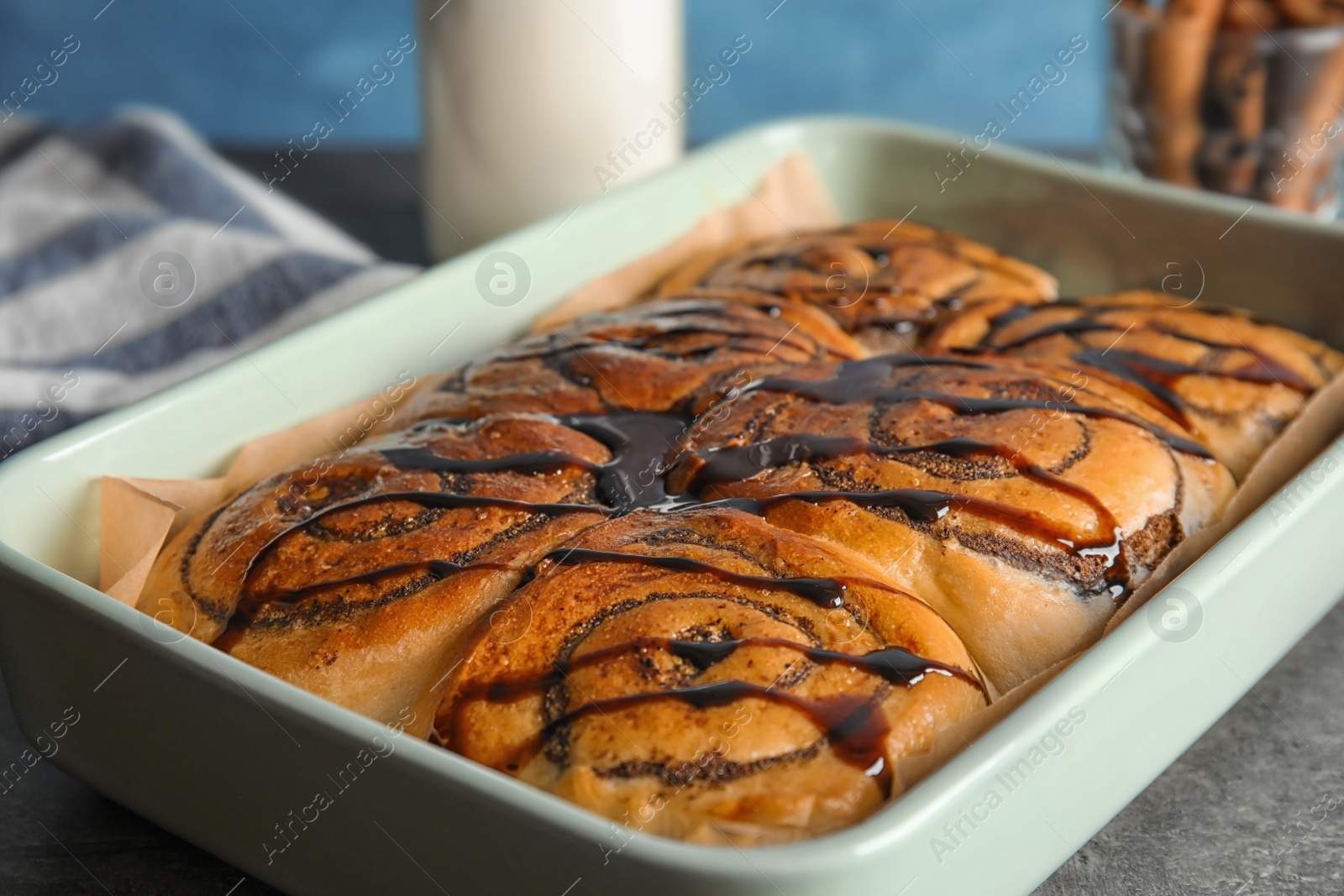 Photo of Baking dish with cinnamon rolls on table, closeup