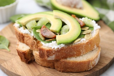 Photo of Tasty vegan sandwich with avocado, tomato and spinach on table, closeup