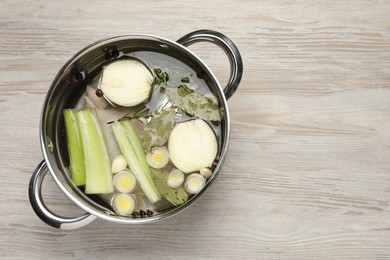 Different ingredients for cooking tasty bouillon in pot on white wooden table, top view. Space for text