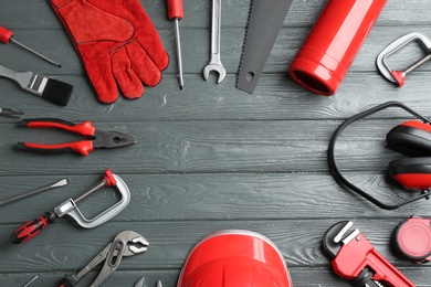 Photo of Flat lay composition with different construction tools and space for text on wooden background