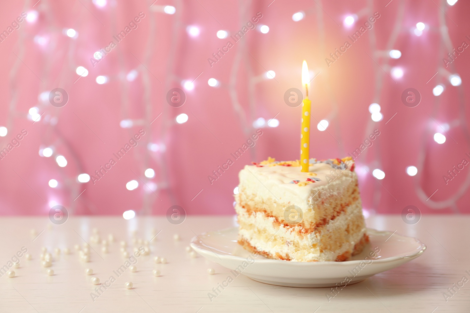 Photo of Slice of delicious birthday cake with candle on table