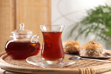 Photo of Traditional Turkish tea and fresh baklava on wicker table