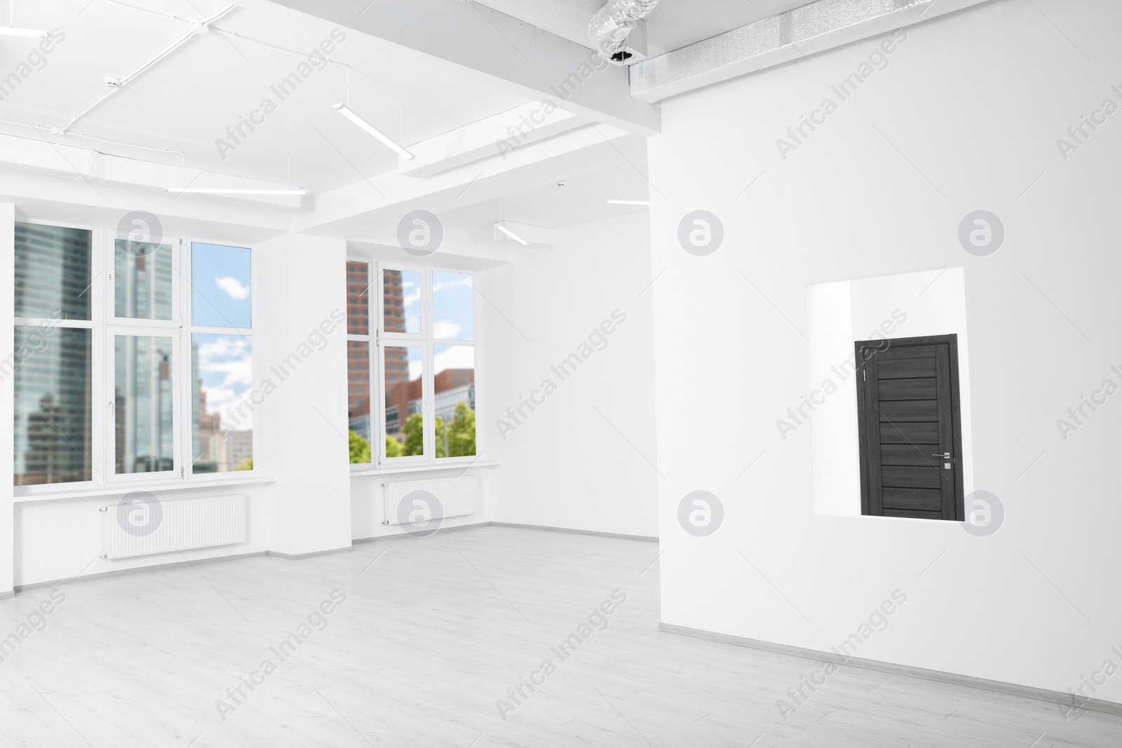 Photo of White walls, windows and opening for fake window in spacious room during repair