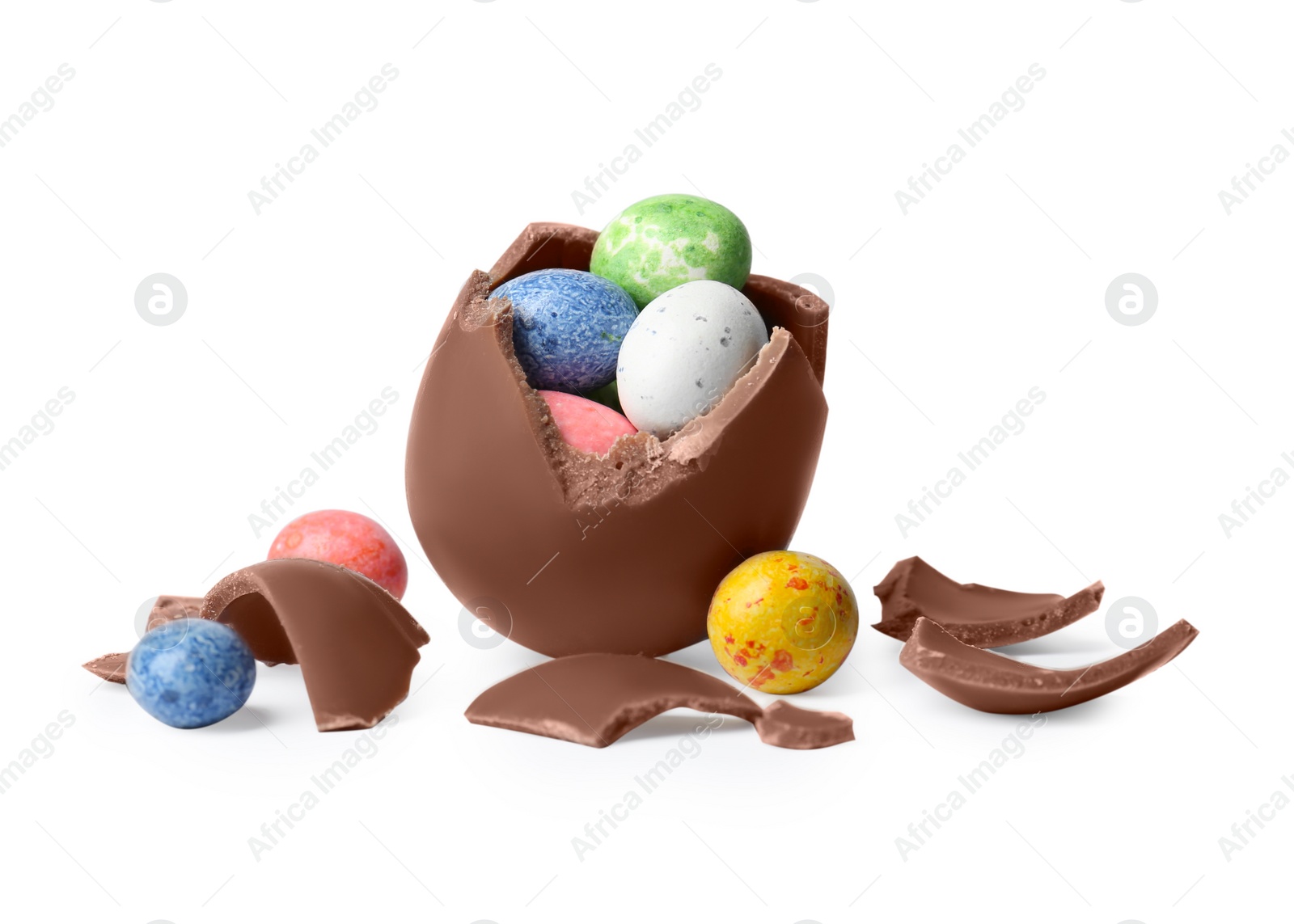 Photo of Tasty broken chocolate egg with colorful candies isolated on white