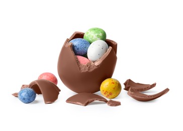 Photo of Tasty broken chocolate egg with colorful candies isolated on white