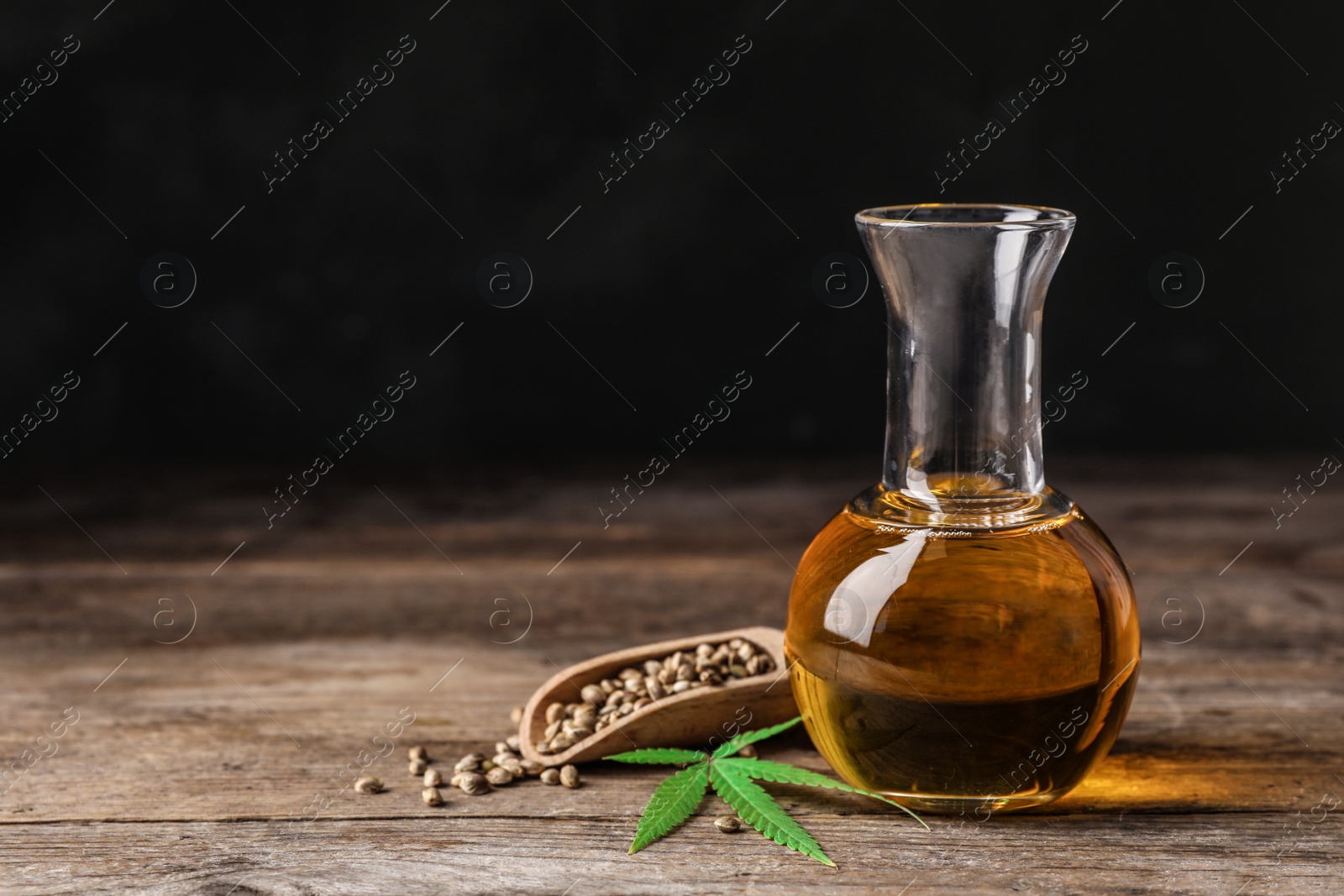 Photo of Composition with hemp oil on wooden table. Space for text