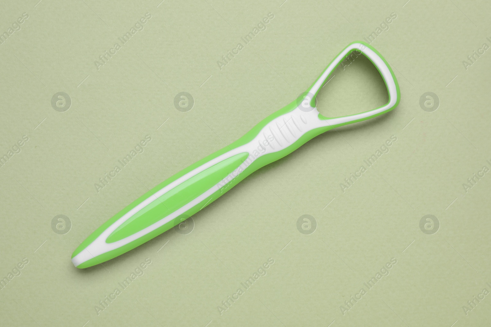 Photo of Green tongue cleaner on olive background, top view