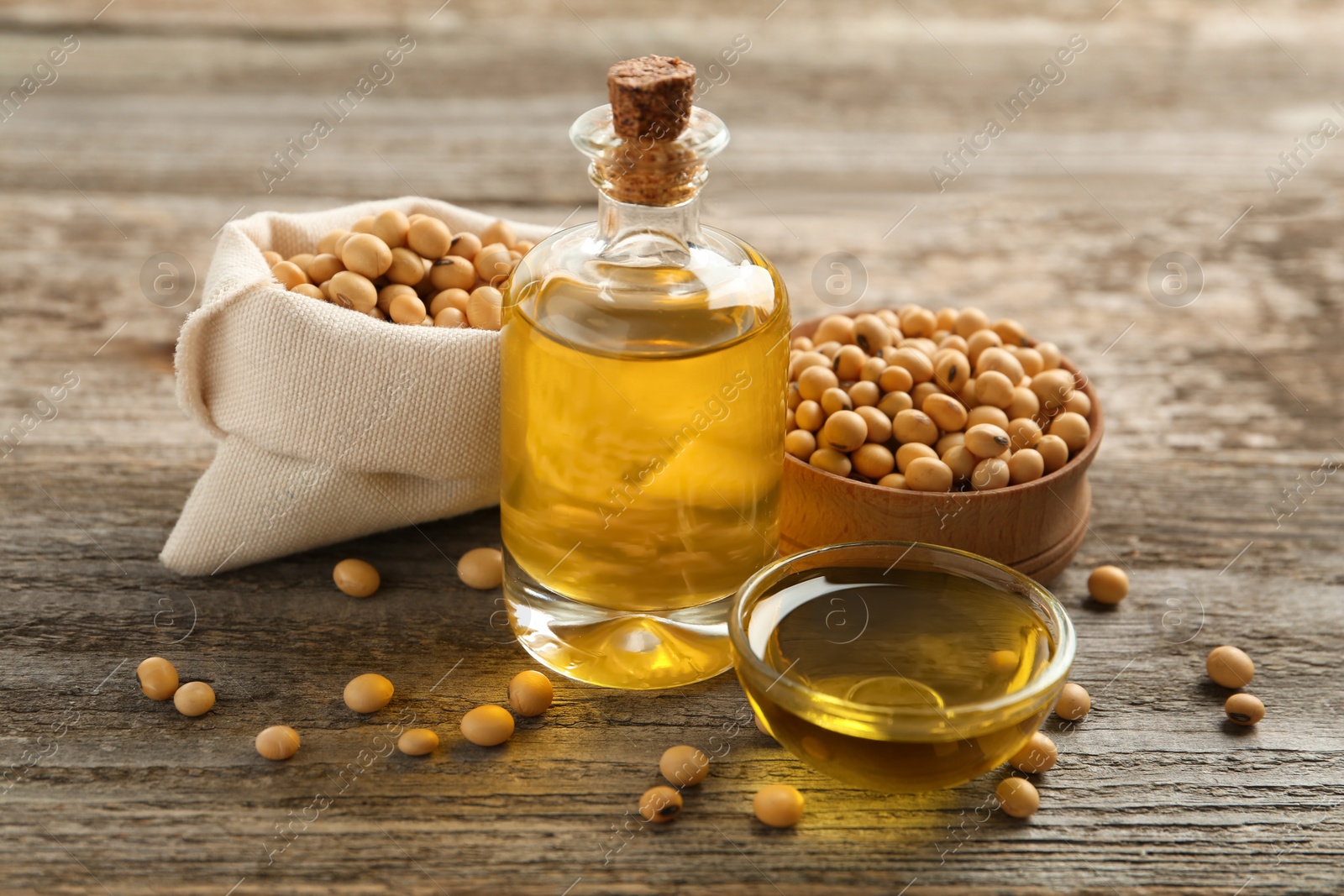 Photo of Composition with soybean oil on wooden table