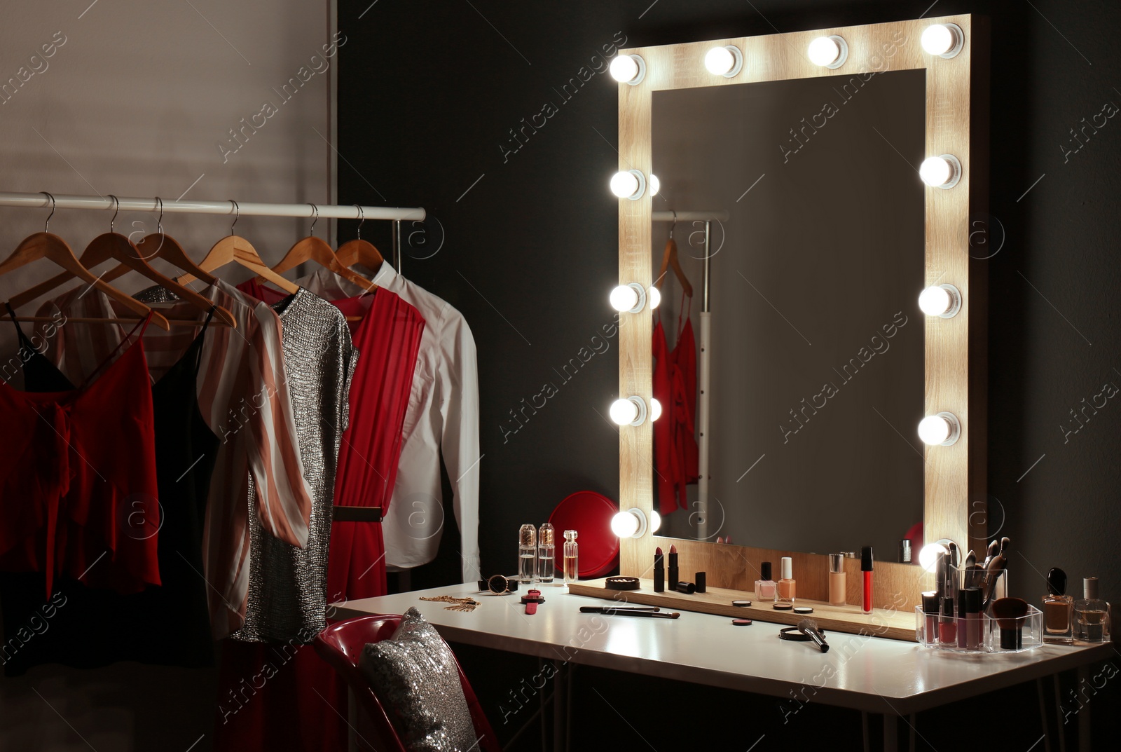 Photo of Stylish room with dressing table, mirror and wardrobe rack