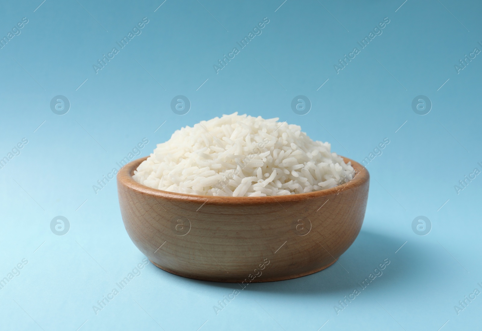 Photo of Bowl of tasty cooked rice on color background