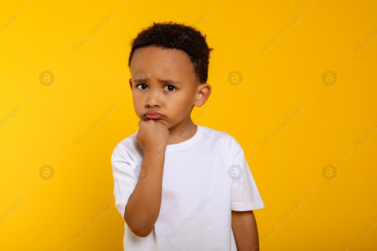 Photo of Portrait of emotional African-American boy on yellow background