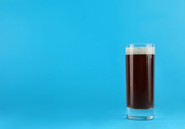 Delicious homemade kvass in glass on light blue background. Space for text