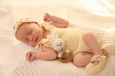 Photo of Adorable newborn baby with toy on knitted plaid