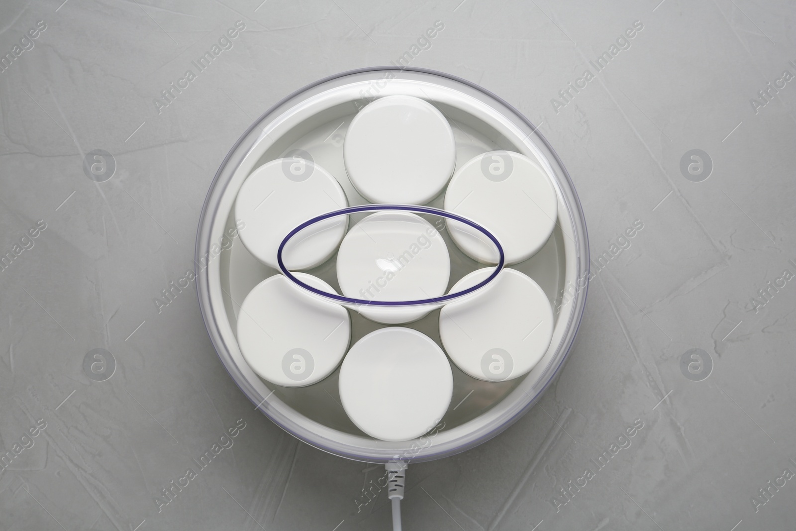 Photo of Modern yogurt maker with jars on light grey table, top view