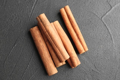 Photo of Aromatic cinnamon sticks on dark grey background