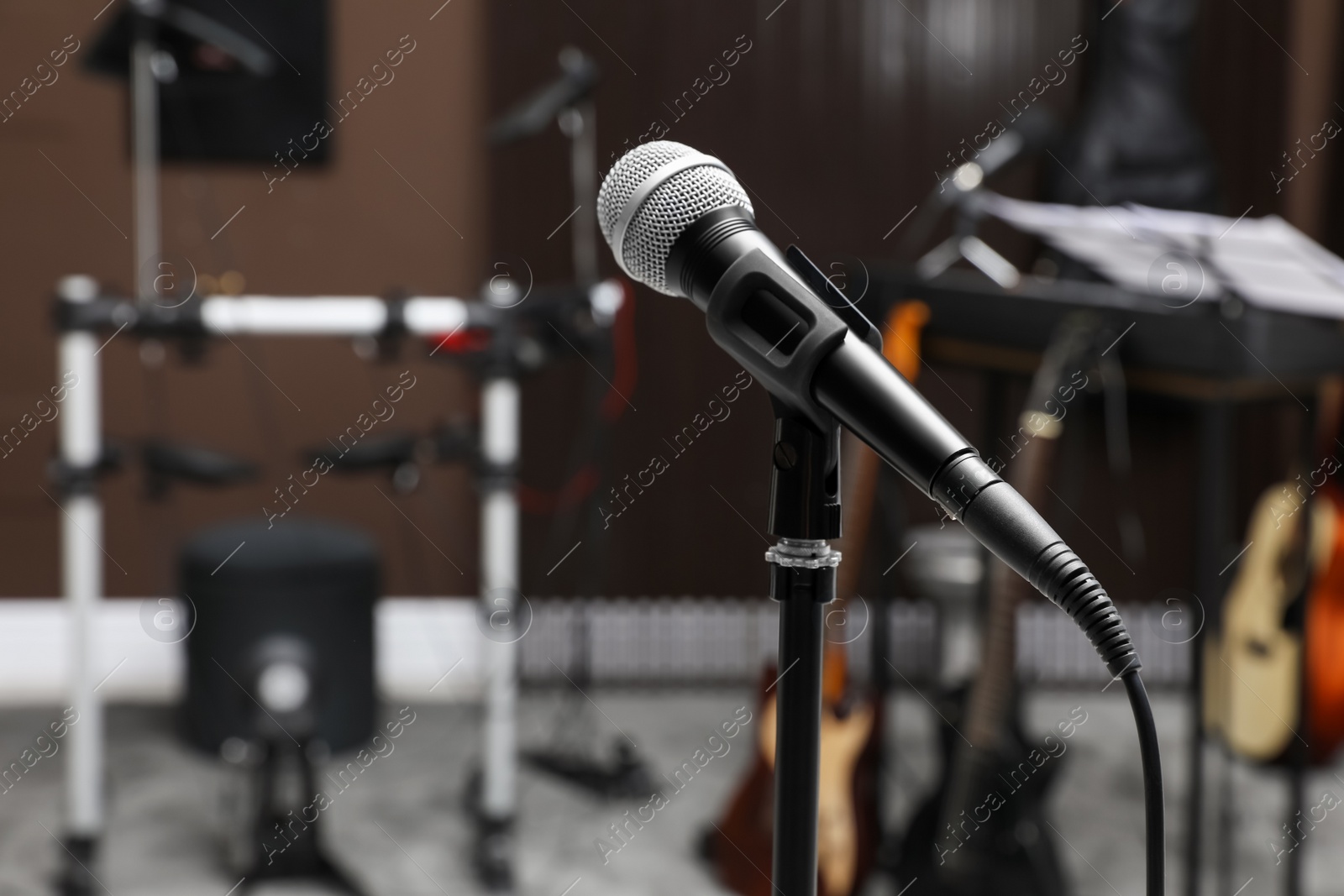 Photo of Modern microphone at recording studio, space for text. Music band practice