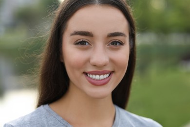 Photo of Portrait of beautiful woman outdoors. Attractive lady smiling and looking into camera