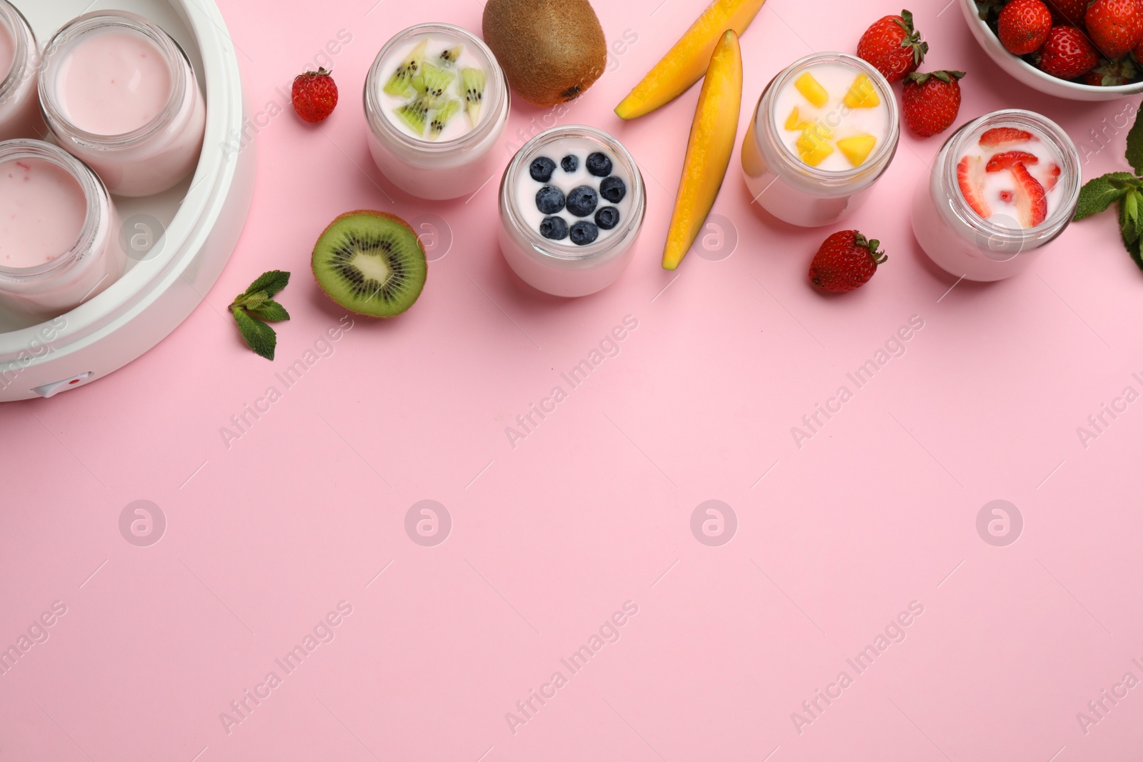 Photo of Tasty yogurt in glass jars and ingredients on pink background, flat lay. Space for text