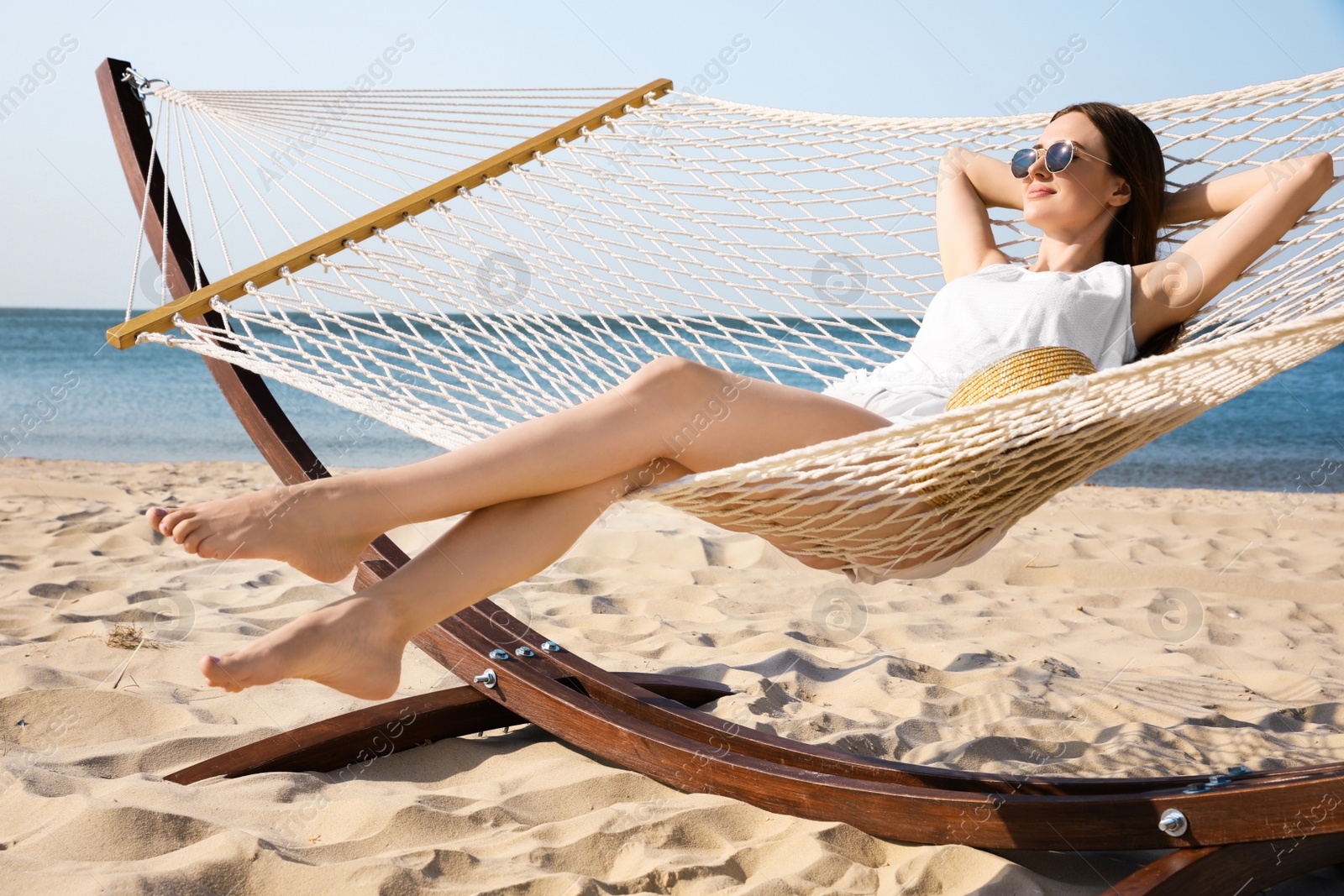 Photo of Young woman relaxing in hammock on beach