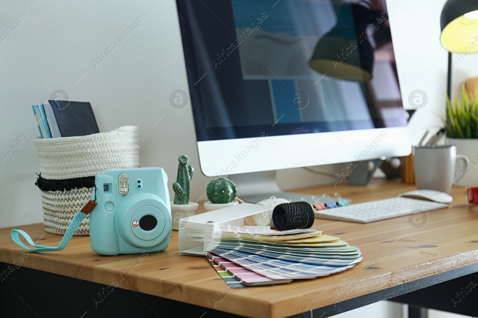 Photo of Digital camera and color palette on table in studio. Modern designer's workplace