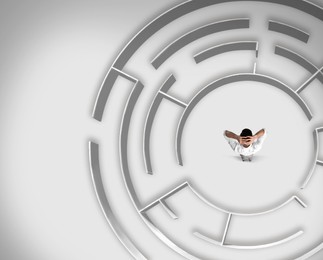 Image of Thoughtful businessman trying to find way out of maze, above view