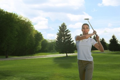 Beautiful woman playing golf on green course, space for text