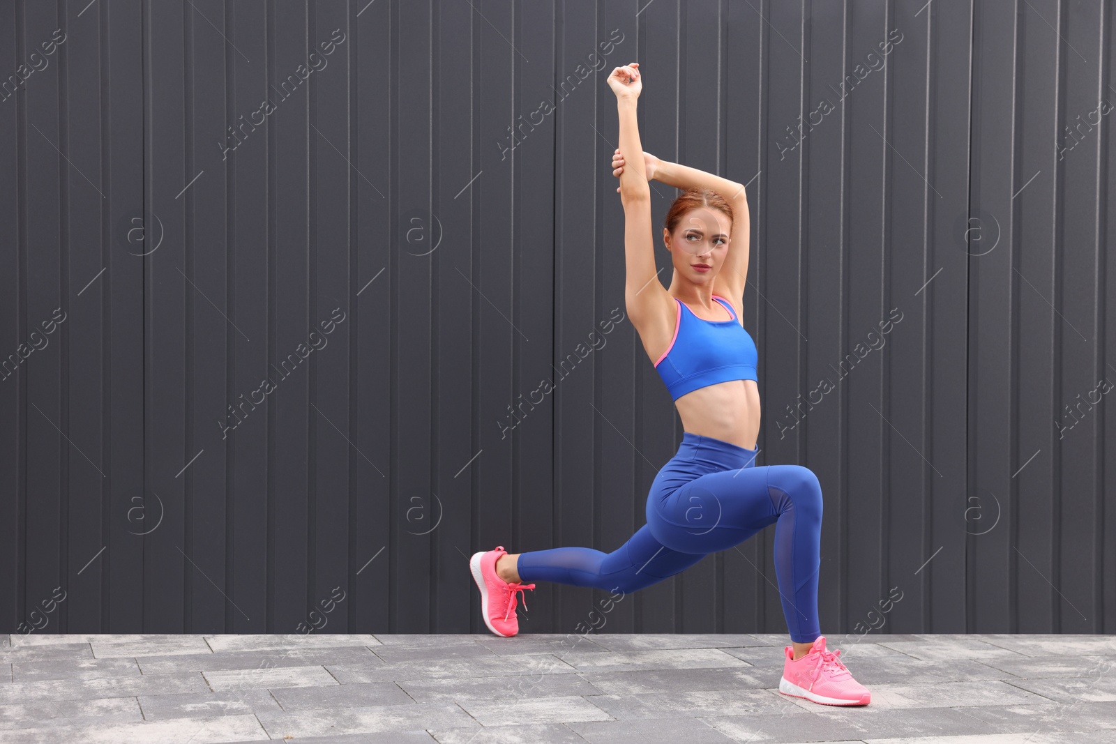 Photo of Beautiful woman in gym clothes doing exercises on street, space for text