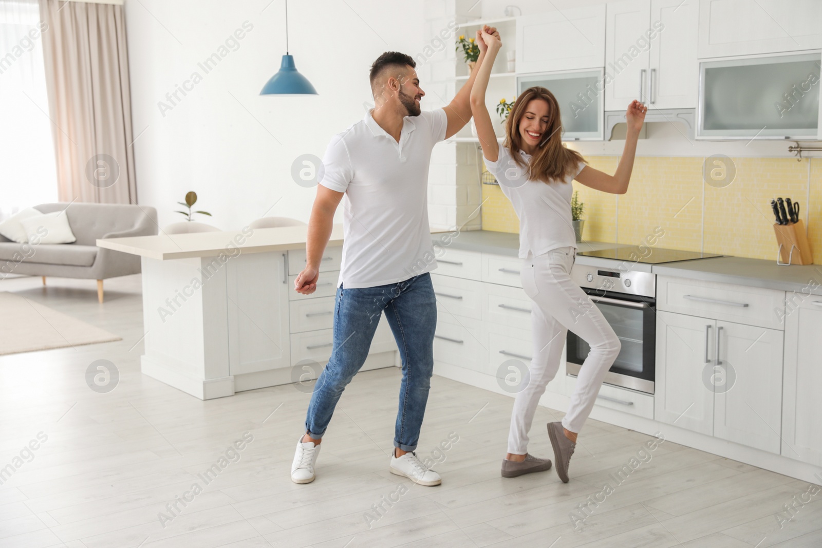 Photo of Lovely young couple dancing in kitchen at home