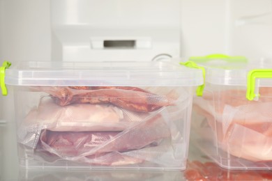 Photo of Vacuum bags with different products in fridge, closeup. Food storage